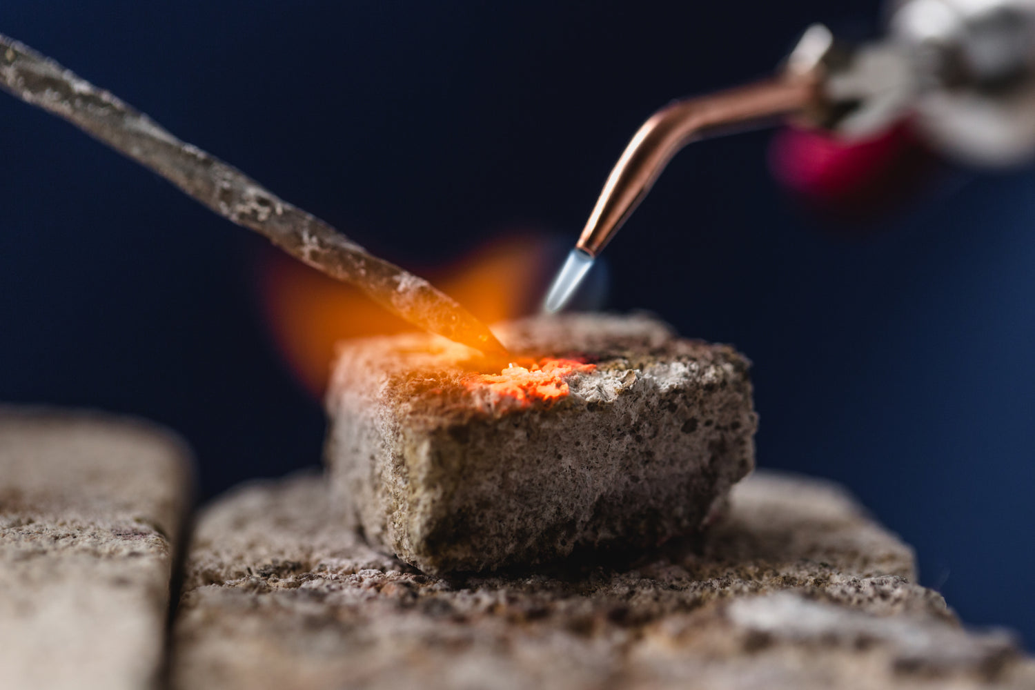a piece of metal being melted down with a torch