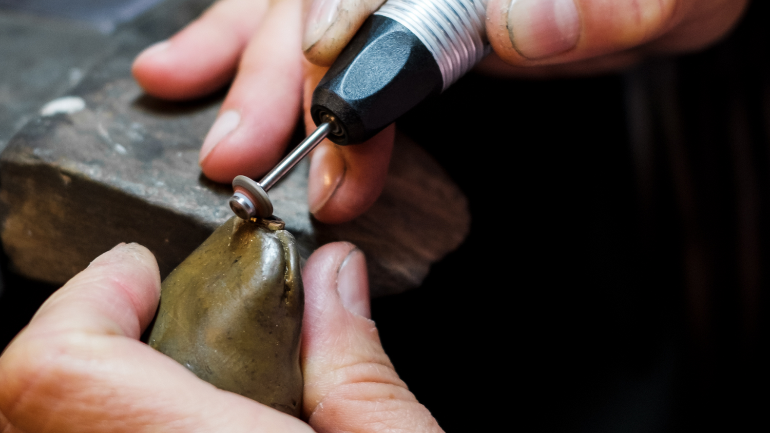 image of a jeweller working on a piece of jewellery with a small power tool